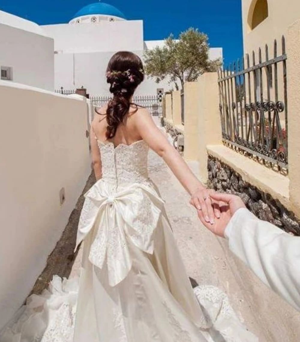 Bridal braided hairstyle with flowers in Santorini streets