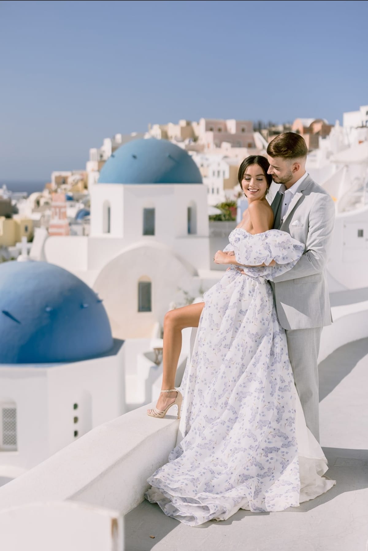 Happy couple in front of blue domes during daytime Santorini