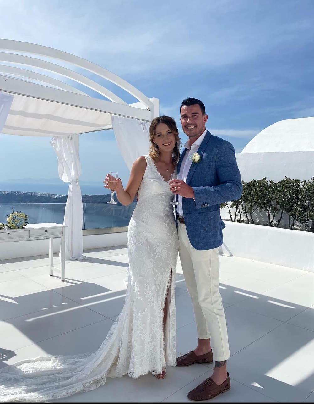 Happy wedding couple on Santorini caldera terrace